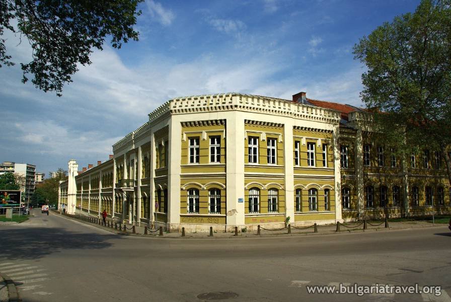 Yellow building with white trim against blue sky.