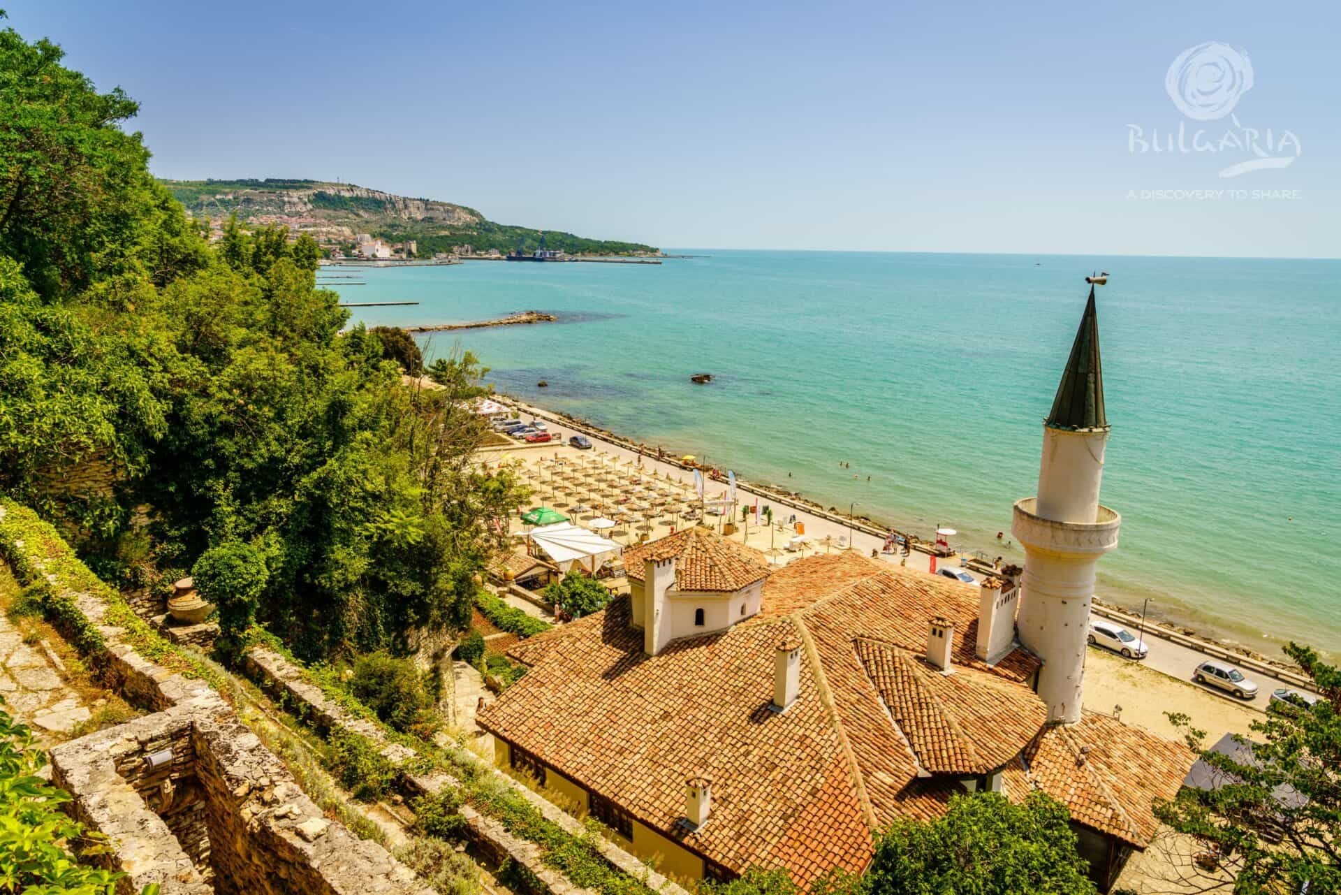 A serene beach with a picturesque church perched on a hillside, creating a beautiful coastal landscape.