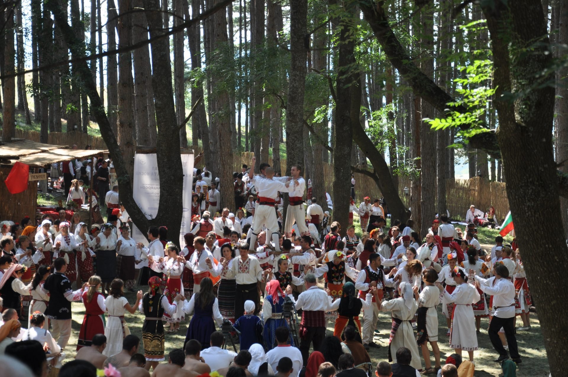 A group of people wearing white and red clothing standing together in a forest.