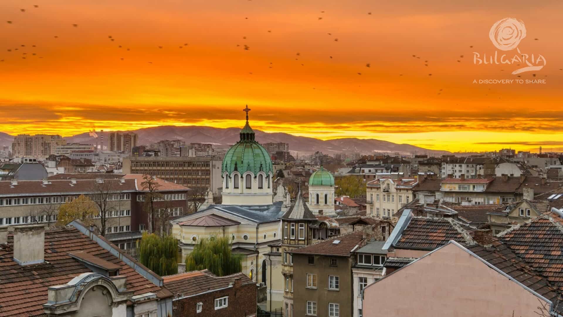 Sunset over the rooftops of Sofia, showcasing the city's beautiful skyline with colorful hues painting the sky.